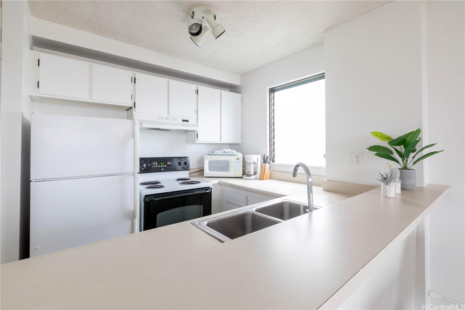 2240 Kūhiō Avenue, Unit 2608 Honolulu, HI 96815 - Photo 8 of 25 a kitchen with white cabinets and a stainless steel appliances