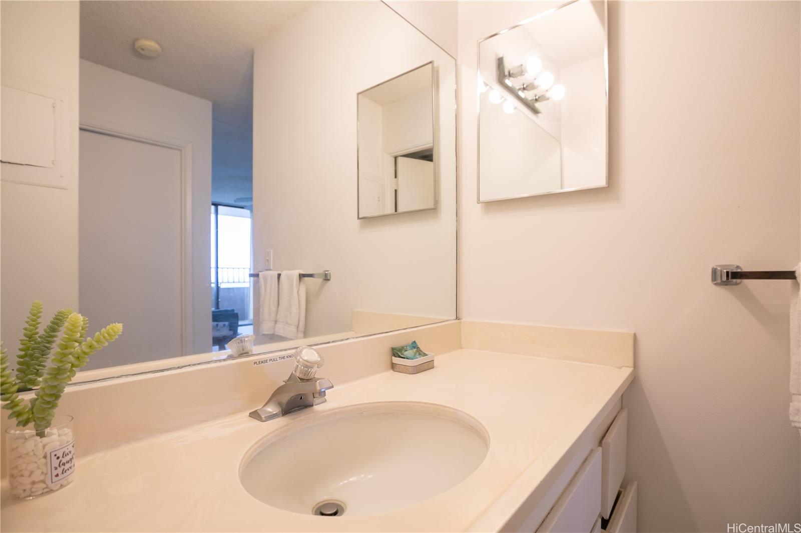2240 Kūhiō Avenue, Unit 2608 Honolulu, HI 96815 - Photo 10 of 25 a bathroom with a sink and a mirror