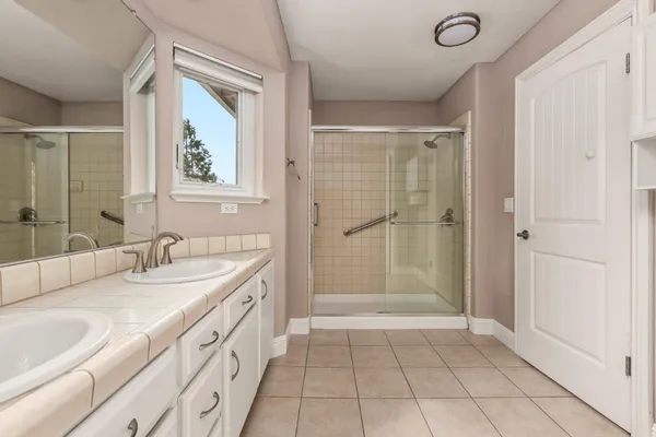 a bathroom with a double vanity sink and mirror with window