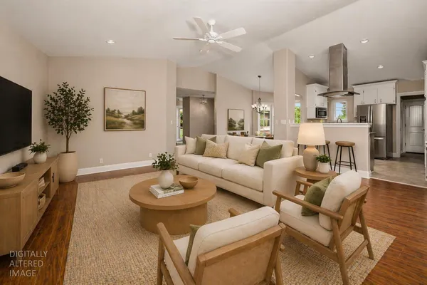 a living room with furniture a flat screen tv and kitchen view