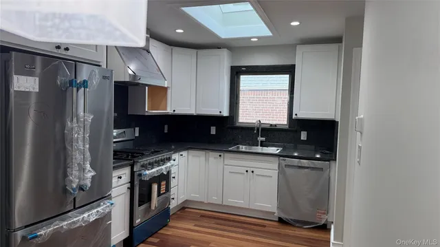 a kitchen with stainless steel appliances a sink stove and refrigerator