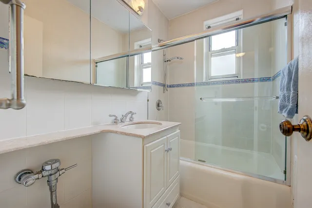 a bathroom with a shower sink and mirror