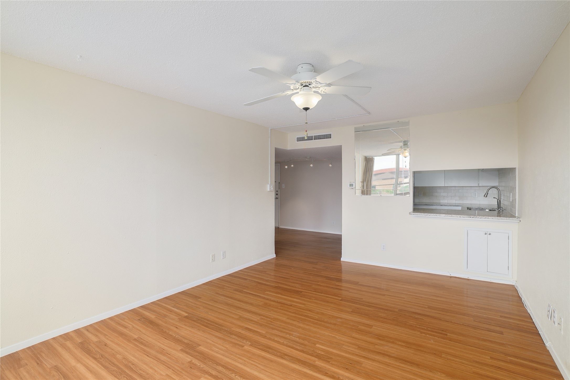 1800 Lavaca Street, Unit A508 Austin, TX 78701 - Photo 15 of 25 Living room featuring laminate flooring and a pass-through to the kitchen.