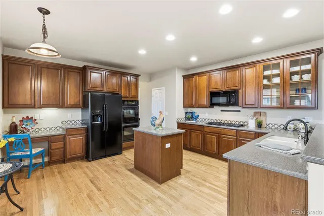 a kitchen with stainless steel appliances granite countertop a refrigerator stove and sink