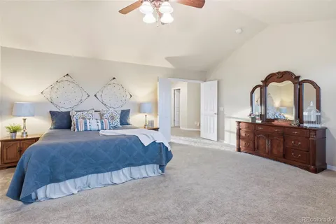 a spacious bedroom with a large bed and wooden floor