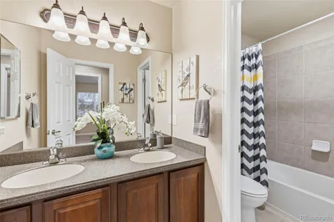 a bathroom with a granite countertop sink a toilet and a mirror