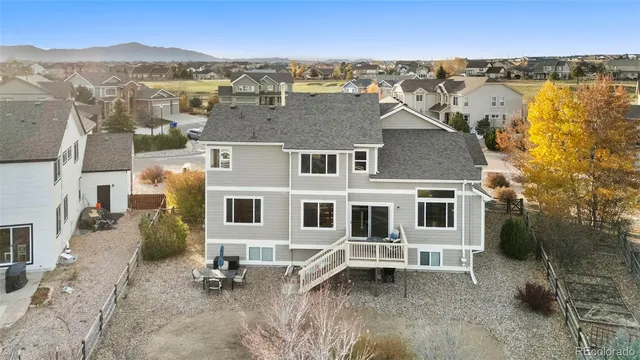 a view of a white house next to a yard with big trees