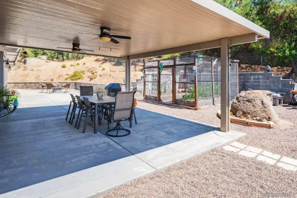 a view of a patio with table and chairs potted plants with floor to ceiling window