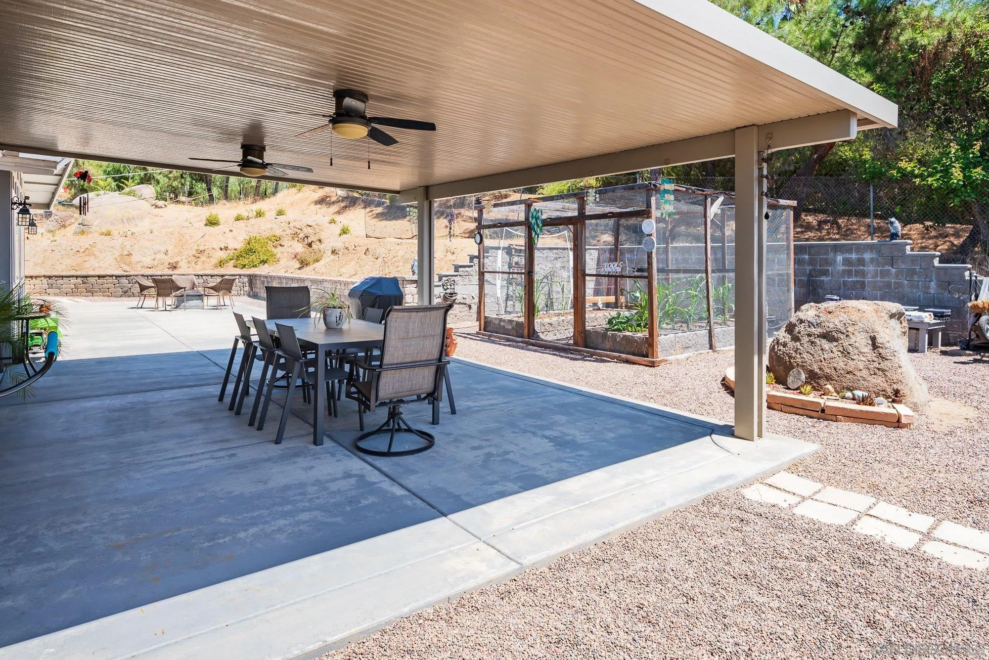 2855 North Victoria Drive Alpine, CA 91901 - Photo 21 of 42 a view of a patio with table and chairs potted plants with floor to ceiling window