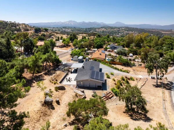 an aerial view of residential house with outdoor space and trees all around