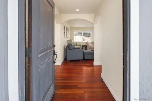 a view of a hallway with furniture and wooden floor