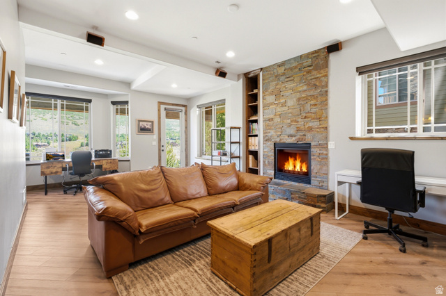 3148 Lower Saddleback Road Park City, UT 84098 - Photo 45 of 67 Open-concept living area featuring wood-finish flooring, a stone-clad fireplace with built-in shelving, recessed lighting, and multiple windows with mountain scenery