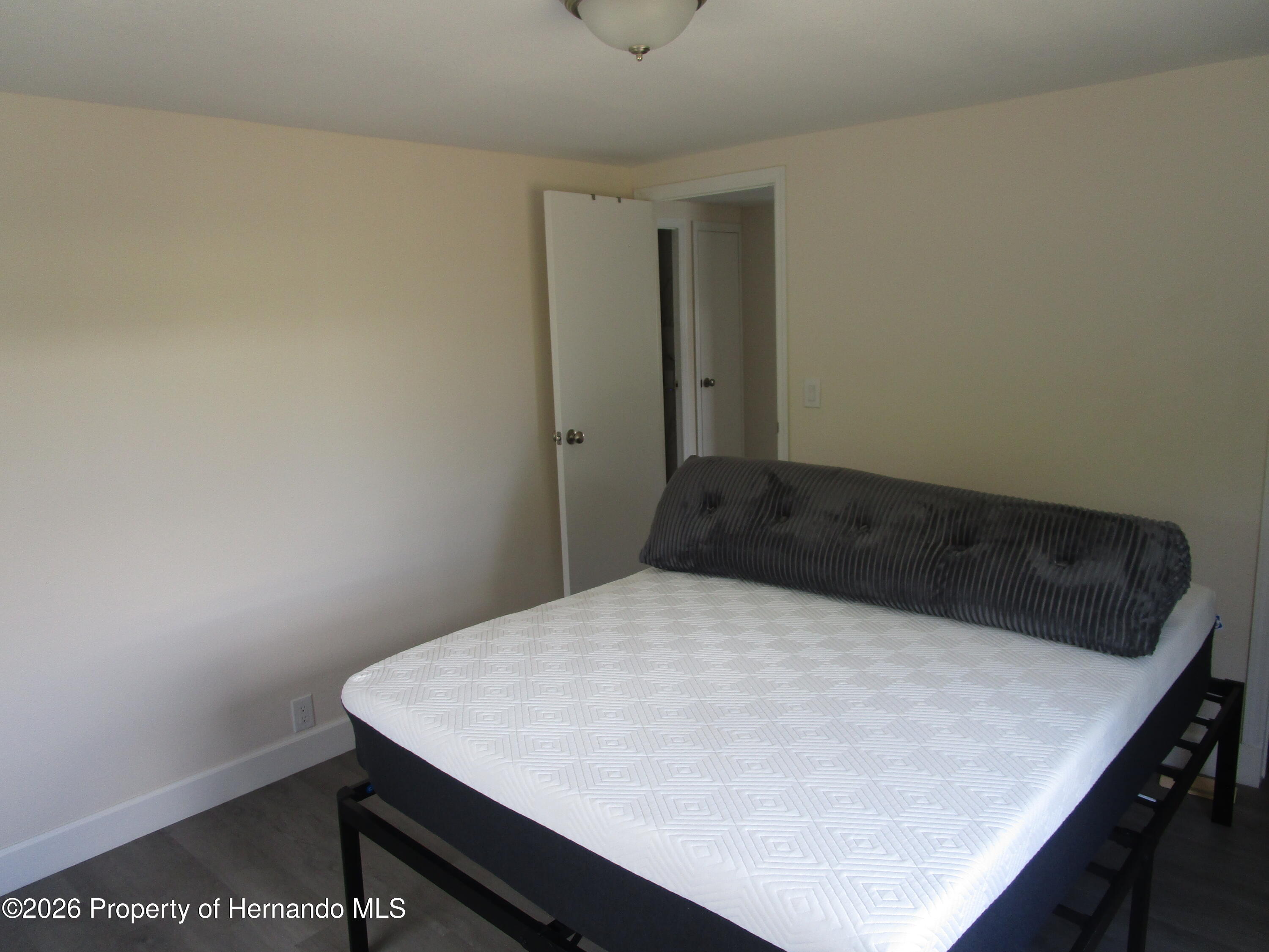 14790 Rialto Avenue, Unit 3 Brooksville, FL 34613 - Photo 10 of 15 a bed sitting in a bedroom next to a window
