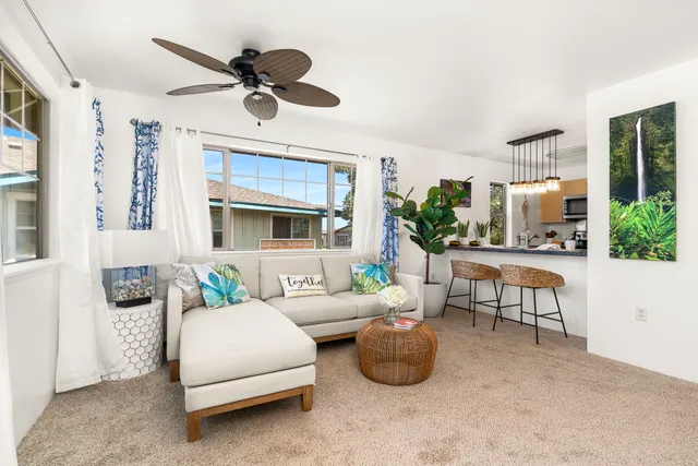 a living room with furniture a fireplace and a chandelier