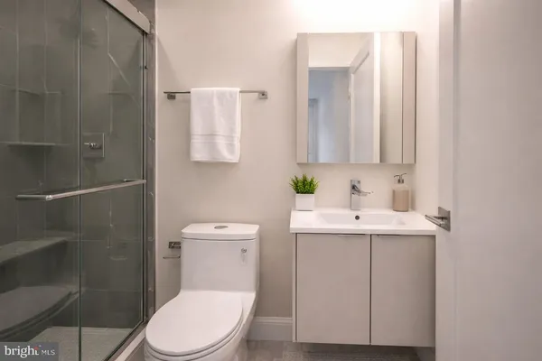 a bathroom with a sink a toilet and shower