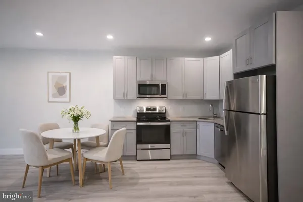 a kitchen with a table chairs refrigerator and microwave