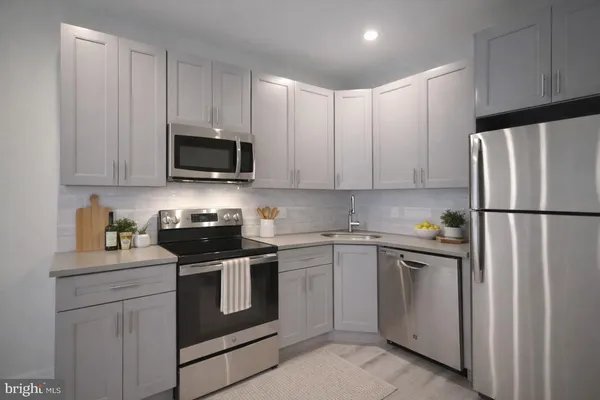a kitchen with stainless steel appliances granite countertop a refrigerator stove a sink and a microwave