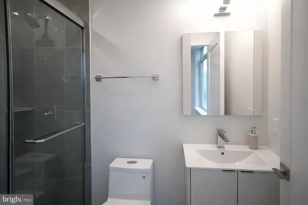 a bathroom with a sink a toilet and shower