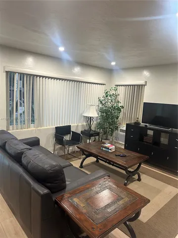 a patio with table and chairs and potted plants