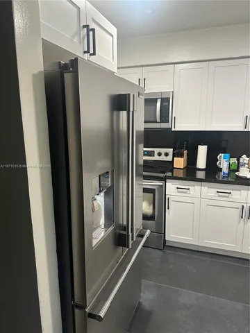 a kitchen with stainless steel appliances a refrigerator and cabinets
