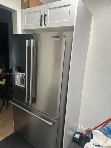 a kitchen with stainless steel appliances kitchen island granite countertop a refrigerator and a stove top oven