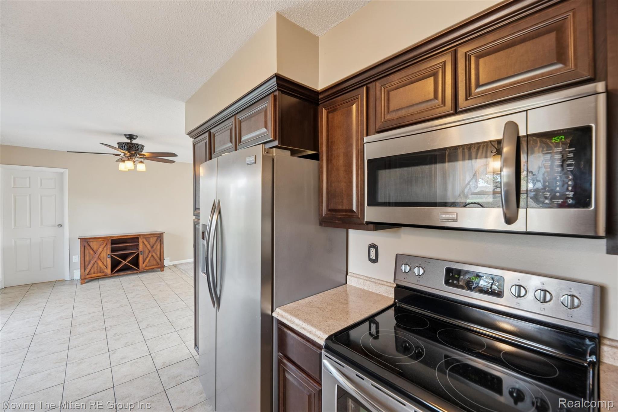 12000 Plank Road Milan, MI 48160 - Photo 14 of 49 Kitchen with stainless steel appliances, light countertops, a ceiling fan, dark wood finish cabinets, and light tile patterned floors