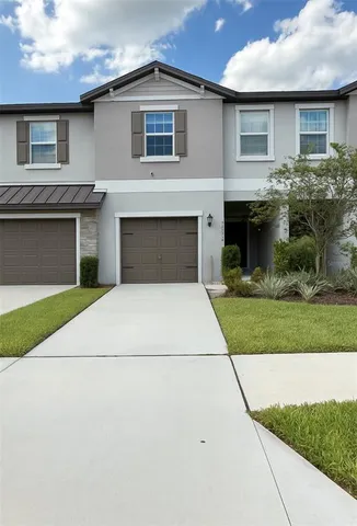 a front view of a house with a garden and garage