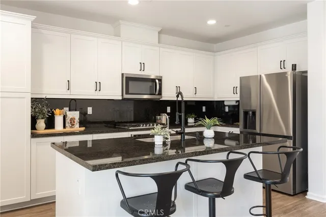 a kitchen with stainless steel appliances a stove a sink and a refrigerator