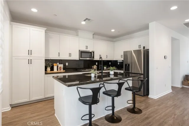 a kitchen with stainless steel appliances granite countertop a refrigerator and a stove top oven