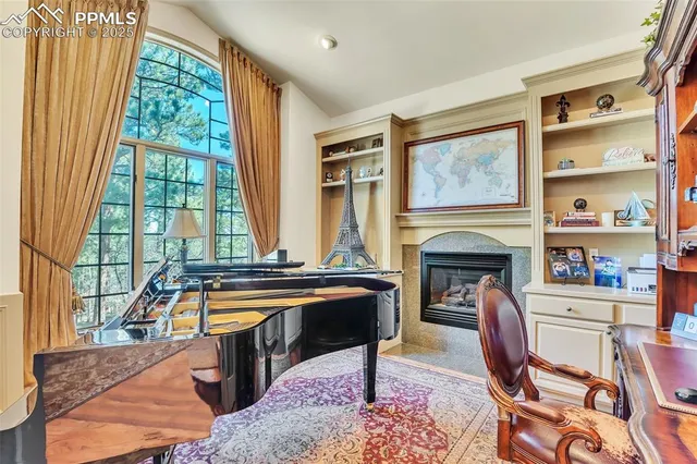 a living room with fireplace furniture and a large window