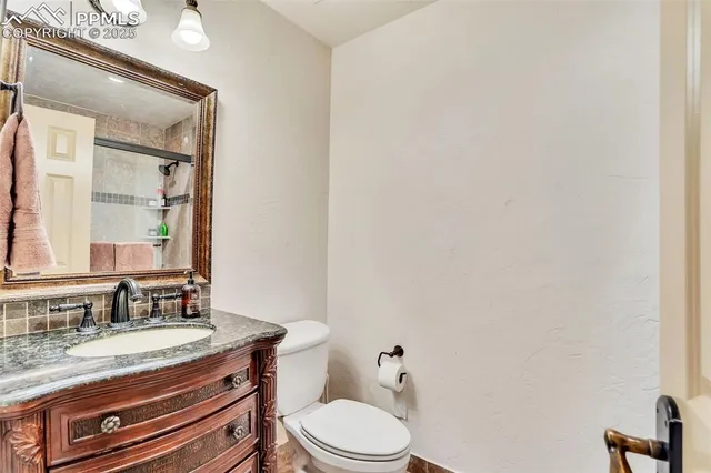a bathroom with a granite countertop toilet sink and mirror
