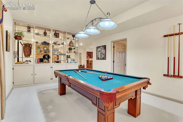 a room with pool table and wall paintings