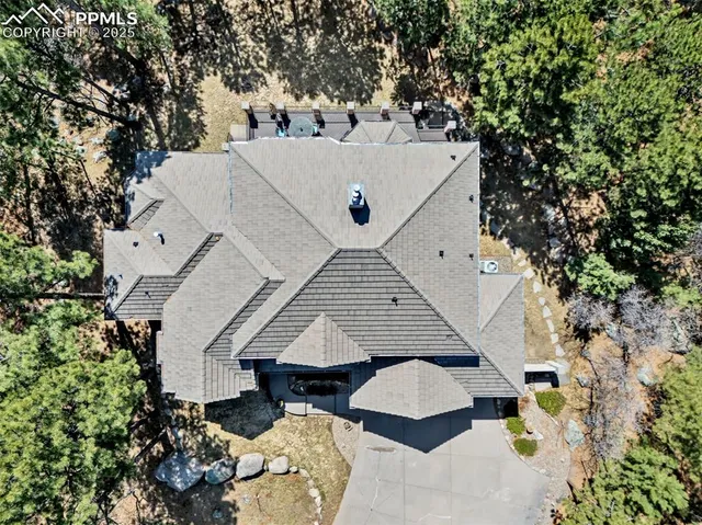 an aerial view of a house with yard and mountain view in back