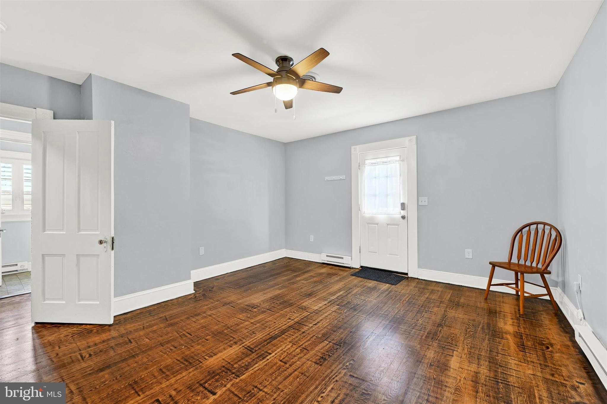 125 West Main Street Westminster, MD 21157 - Photo 13 of 31 an empty room with wooden floor chandelier fan and windows