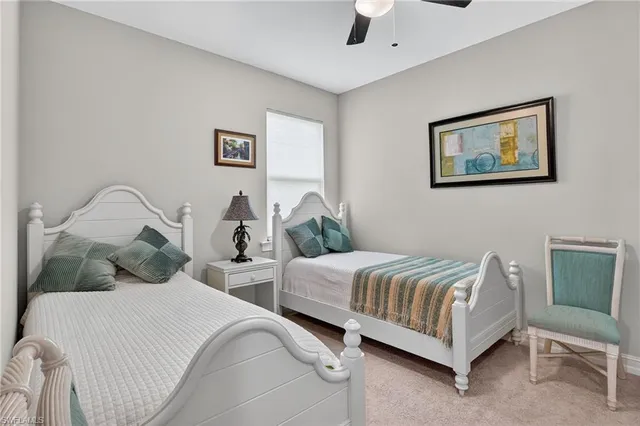 a bedroom with two beds and painting on the wall