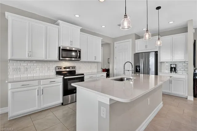 a kitchen with kitchen island a sink and a stove