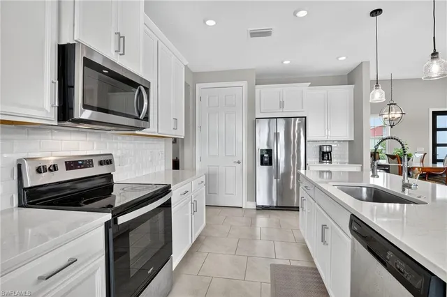 a kitchen with stainless steel appliances a stove microwave and sink