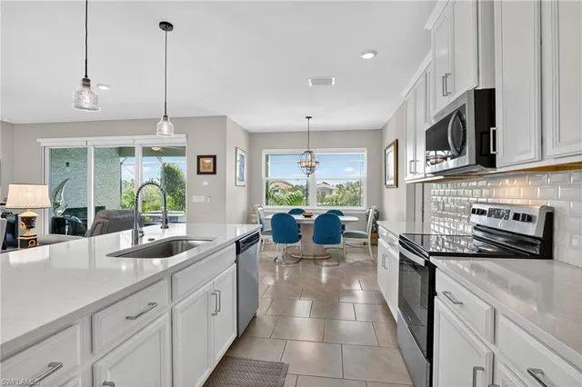 a kitchen with stainless steel appliances kitchen island granite countertop a sink a stove and cabinets