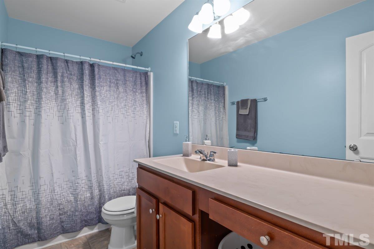 3529 Eastern Branch Road Raleigh, NC 27610 - Photo 22 of 24 a bathroom with a sink a toilet and a mirror
