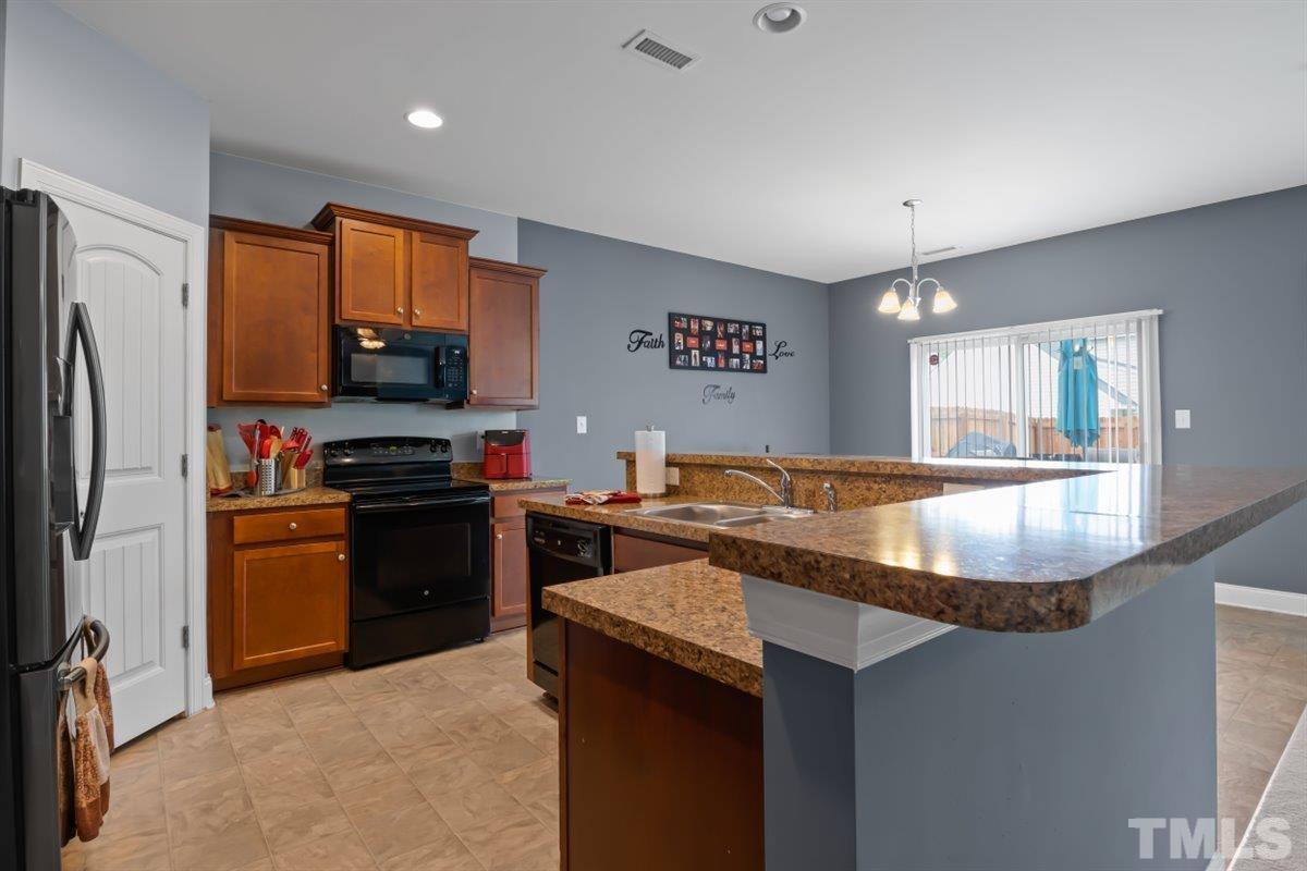 3529 Eastern Branch Road Raleigh, NC 27610 - Photo 6 of 24 a kitchen with stainless steel appliances granite countertop a sink stove and refrigerator