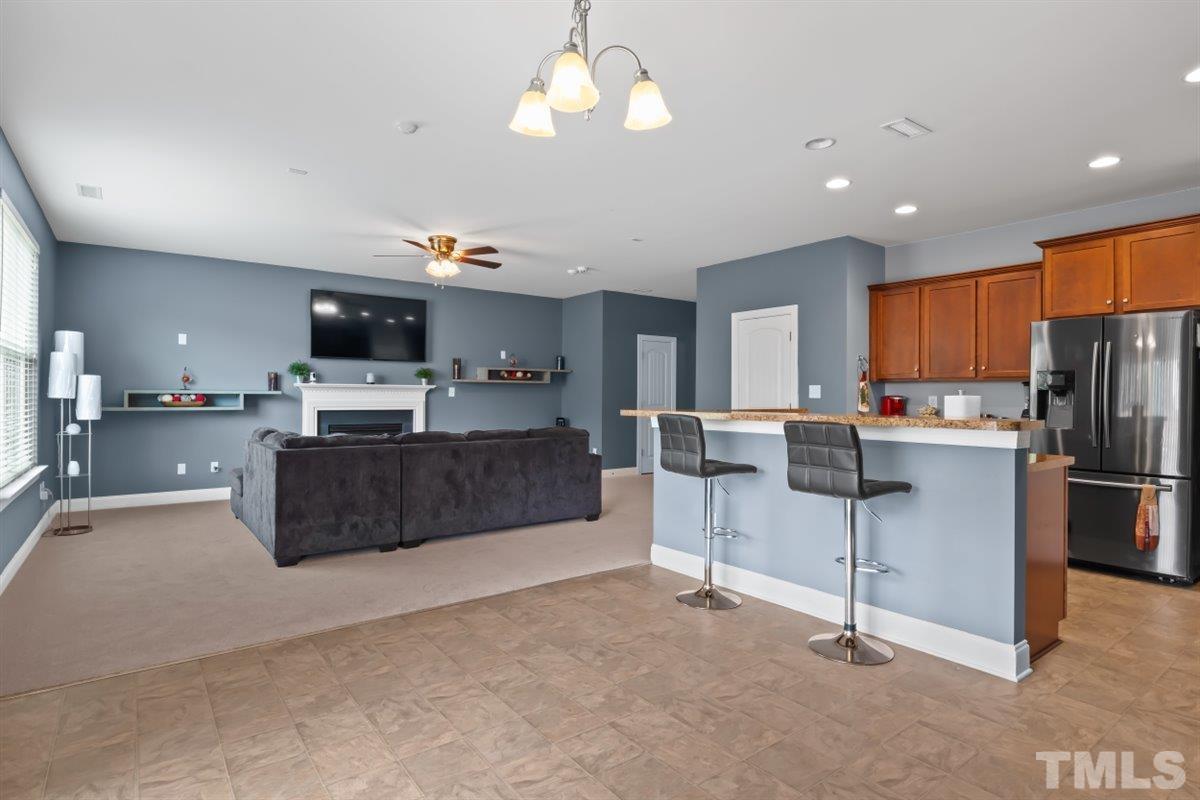 3529 Eastern Branch Road Raleigh, NC 27610 - Photo 9 of 24 a kitchen with stainless steel appliances kitchen island granite countertop a refrigerator oven a sink dishwasher a dining table and chairs with wooden floor