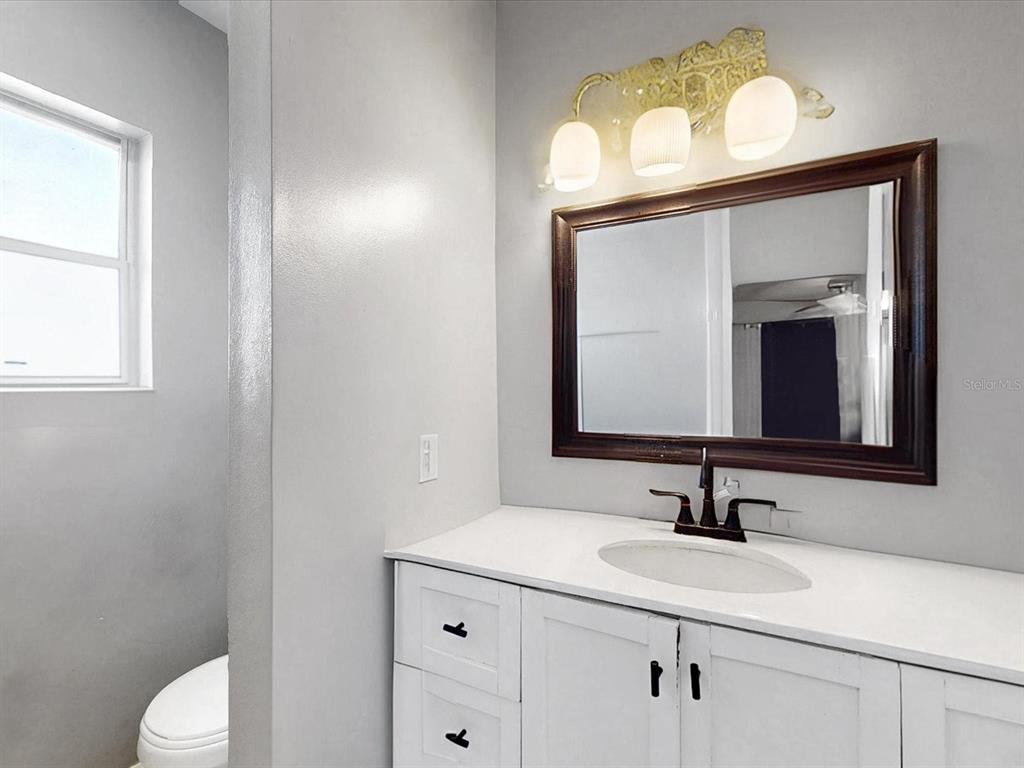 2615 Cecile Street Kissimmee, FL 34741 - Photo 18 of 30 a bathroom with a toilet sink and mirror