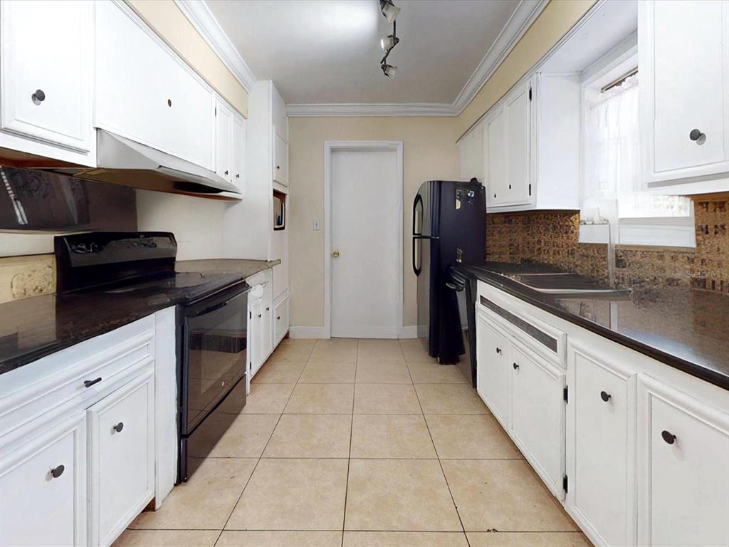 2615 Cecile Street Kissimmee, FL 34741 - Photo 8 of 30 a kitchen with granite countertop a refrigerator and a sink