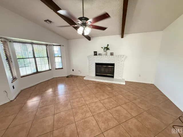 a view of empty room with cabinet and fireplace