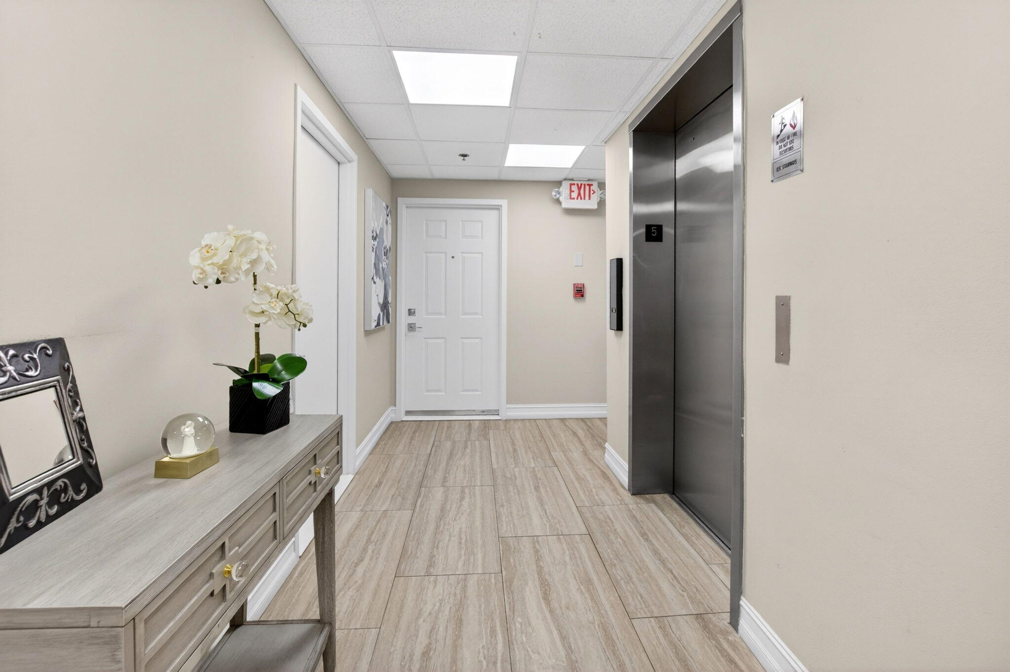 950 De Soto Road, Unit 5A Boca Raton, FL 33432 - Photo 63 of 98 a view of a hallway to a livingroom with wooden floor and furniture