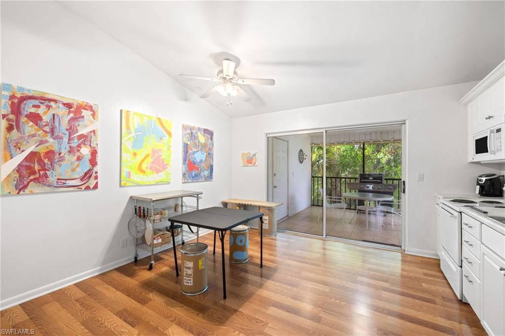 5406 16th Place Southwest, Unit E4 Naples, FL 34116 - Photo 16 of 26 a dining room with furniture a floor to ceiling window and wooden floor