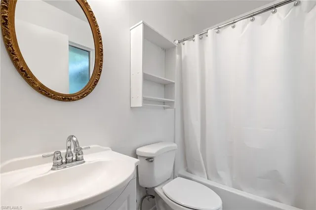 a bathroom with a toilet a sink and a mirror