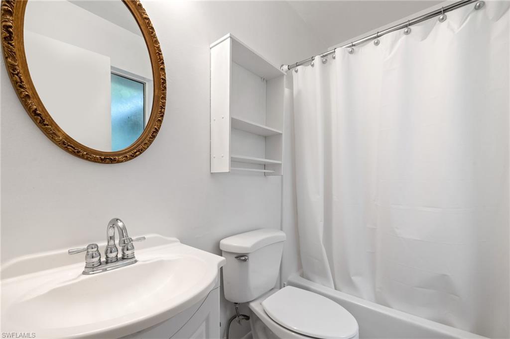 5406 16th Place Southwest, Unit E4 Naples, FL 34116 - Photo 21 of 26 a bathroom with a toilet a sink and a mirror