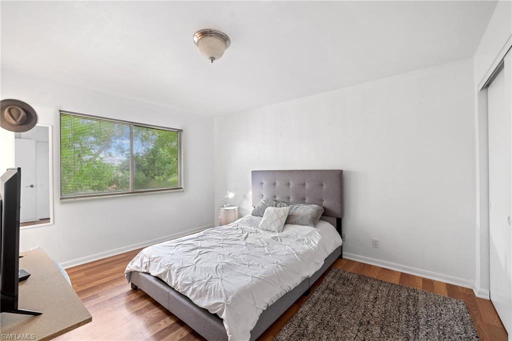 5406 16th Place Southwest, Unit E4 Naples, FL 34116 - Photo 23 of 26 a bedroom with a bed and a window