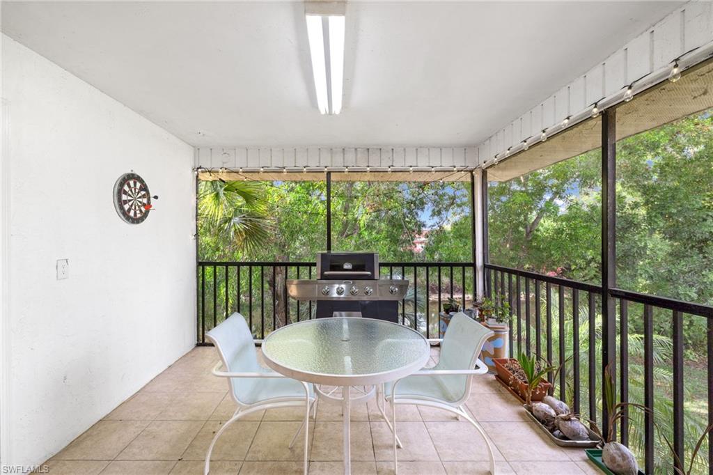 5406 16th Place Southwest, Unit E4 Naples, FL 34116 - Photo 10 of 26 a balcony with table and chairs